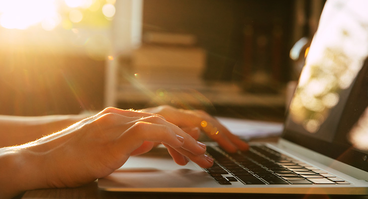 Close up of someone typing on a laptop